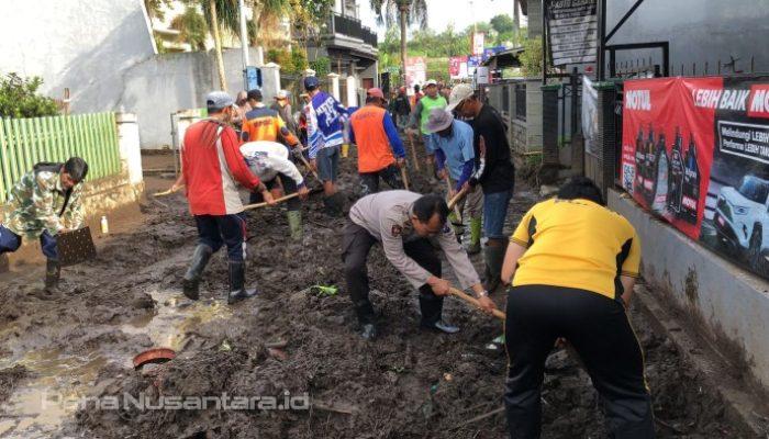 Sinergitas Polres Batu Bersama TNI dan Warga Bersihkan Lumpur Akibat Banjir Lalulintas Kembali Lancar